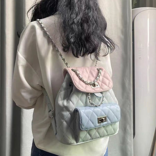 Person wearing a pastel quilted backpack with a chain detail.