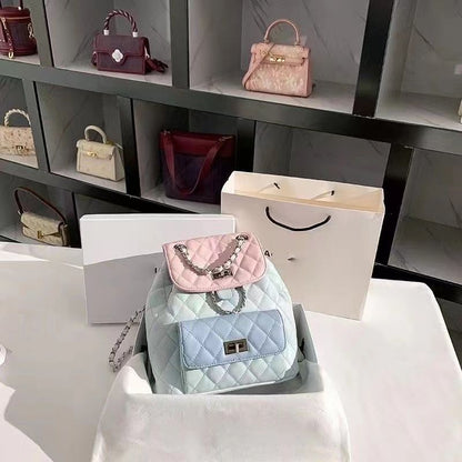Display of handbags including a pink and blue quilted bag on a white surface with shelves in the background.