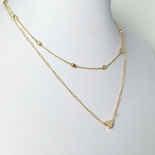 Gold necklace with a heart pendant on a mannequin bust.