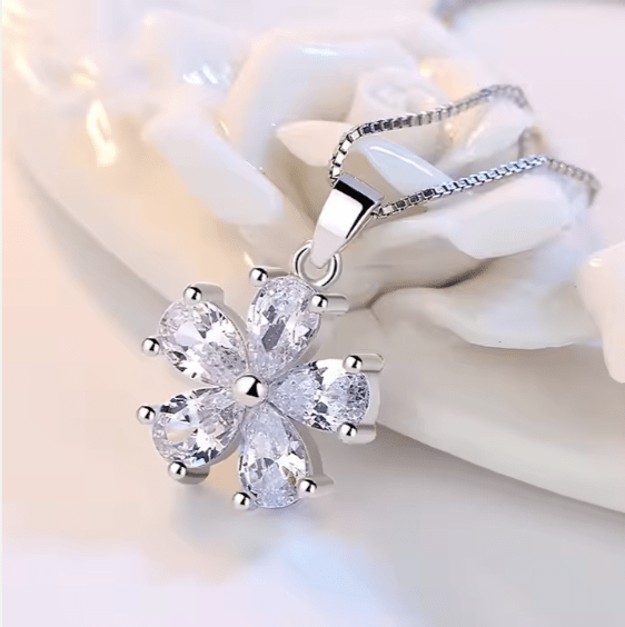 Silver necklace with a floral pendant on a white background